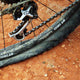 Close-up of a flat mountain bike tire, showing the deflated tube and rim.
